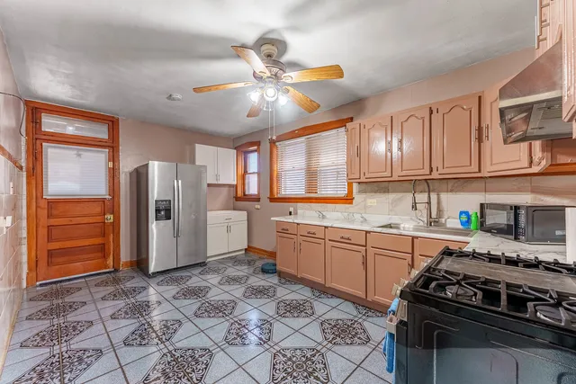 a kitchen with stainless steel appliances granite countertop a stove a refrigerator and a cabinets