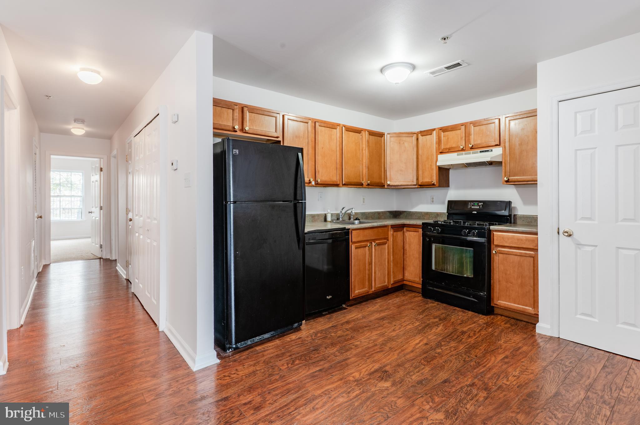 9228 Blue Grass Road, Unit 39 Philadelphia, PA 19114 - Photo 6 of 21 a kitchen with granite countertop a refrigerator and a stove top oven
