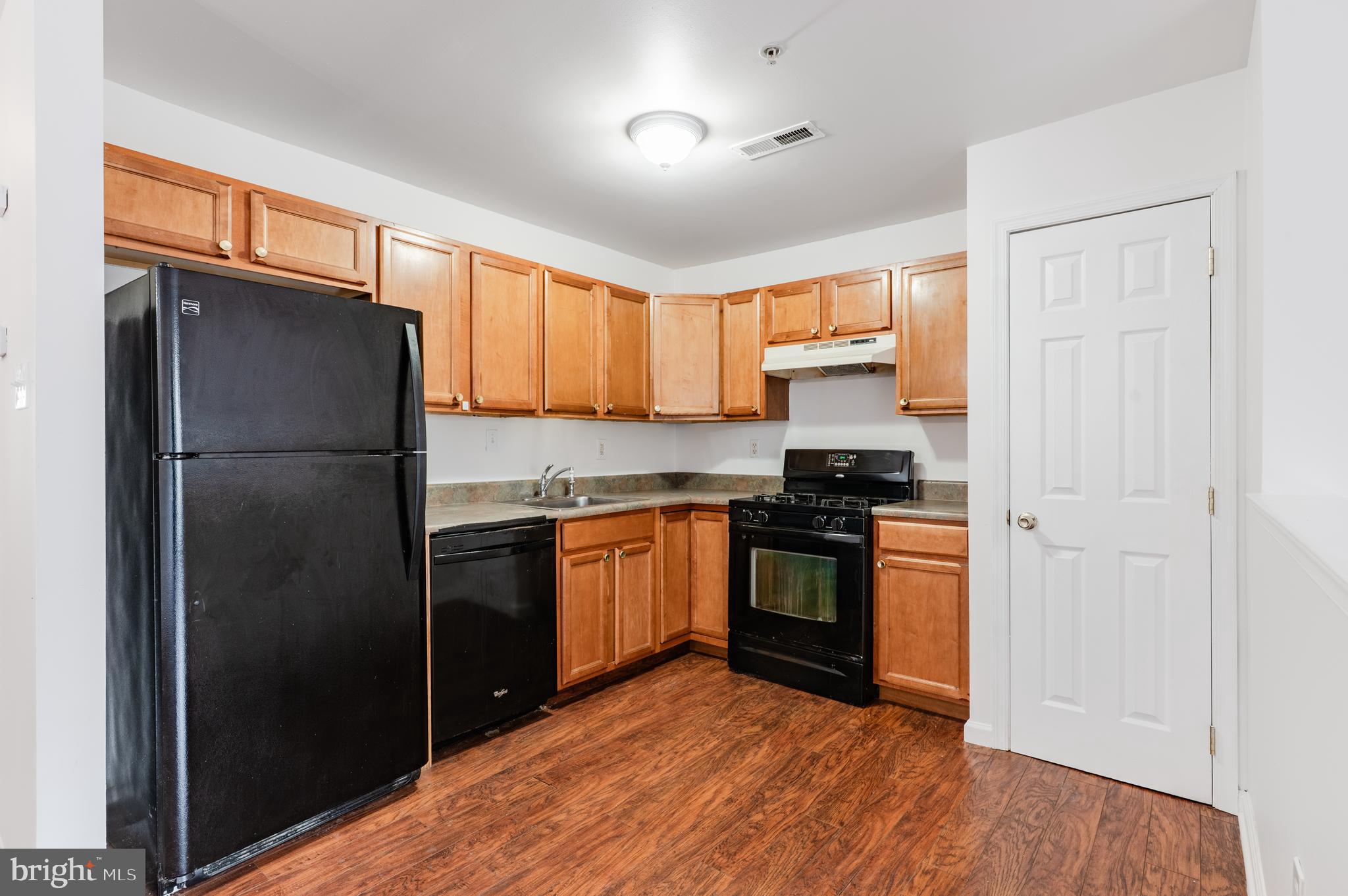 9228 Blue Grass Road, Unit 39 Philadelphia, PA 19114 - Photo 7 of 21 a kitchen with granite countertop stainless steel appliances a refrigerator a stove a sink and a window