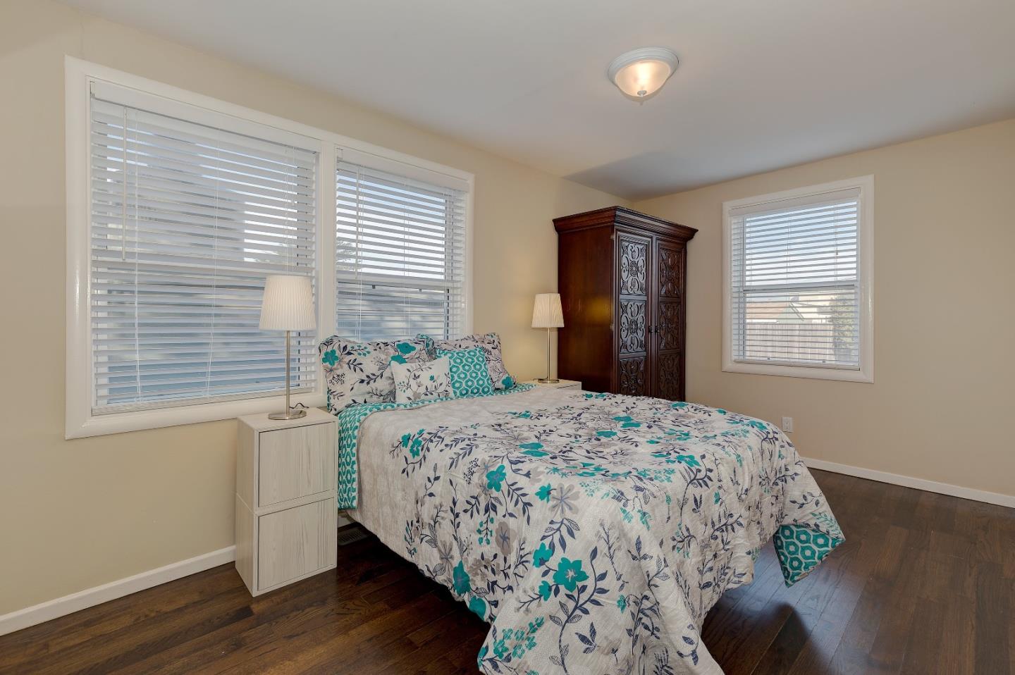 263 Clarendon Road Pacifica, CA 94044 - Photo 15 of 36 a bedroom with a bed and wooden floor