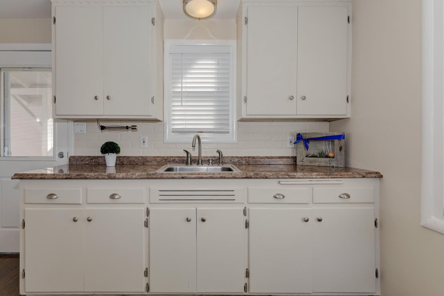 263 Clarendon Road Pacifica, CA 94044 - Photo 20 of 36 a kitchen with granite countertop white cabinets and sink