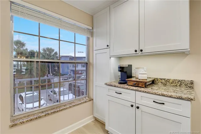 a kitchen with stainless steel appliances granite countertop a stove and a white cabinets