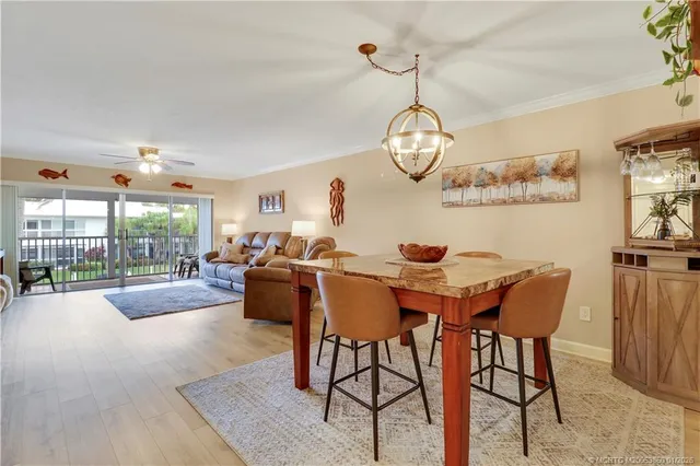 a view of a dining room and livingroom with furniture wooden floor a rug and a chandelier