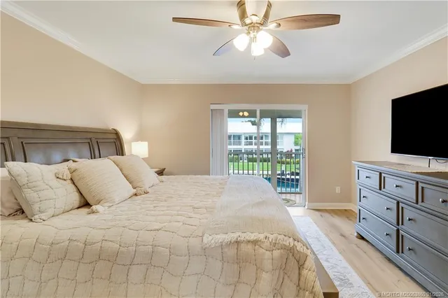 a bedroom with a large bed and a flat tv screen on dresser