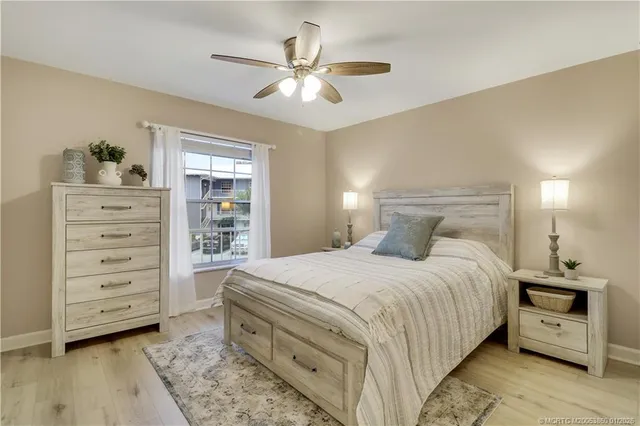 a bedroom with a bed and a ceiling fan
