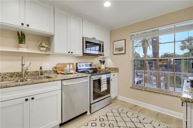 a kitchen with stainless steel appliances granite countertop a stove and a sink