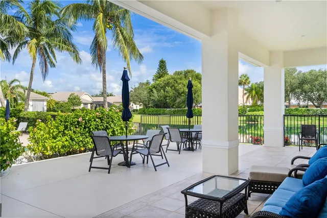 a view of a patio with a table and chairs and potted plants