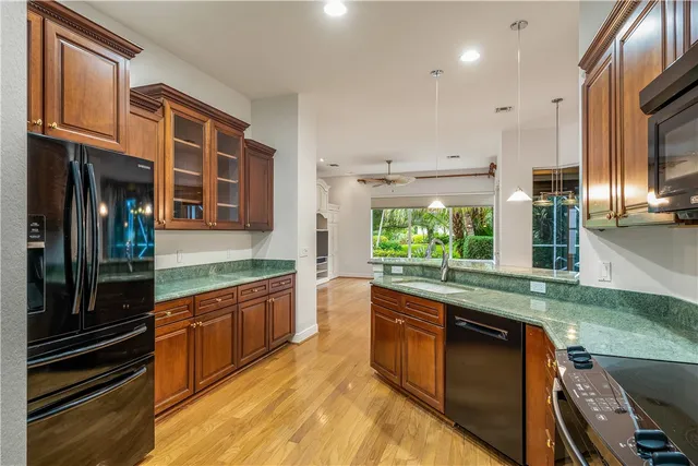 a large kitchen with stainless steel appliances granite countertop a stove and a sink