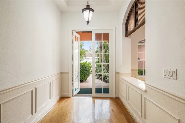 a view of a hallway with wooden floor and windows