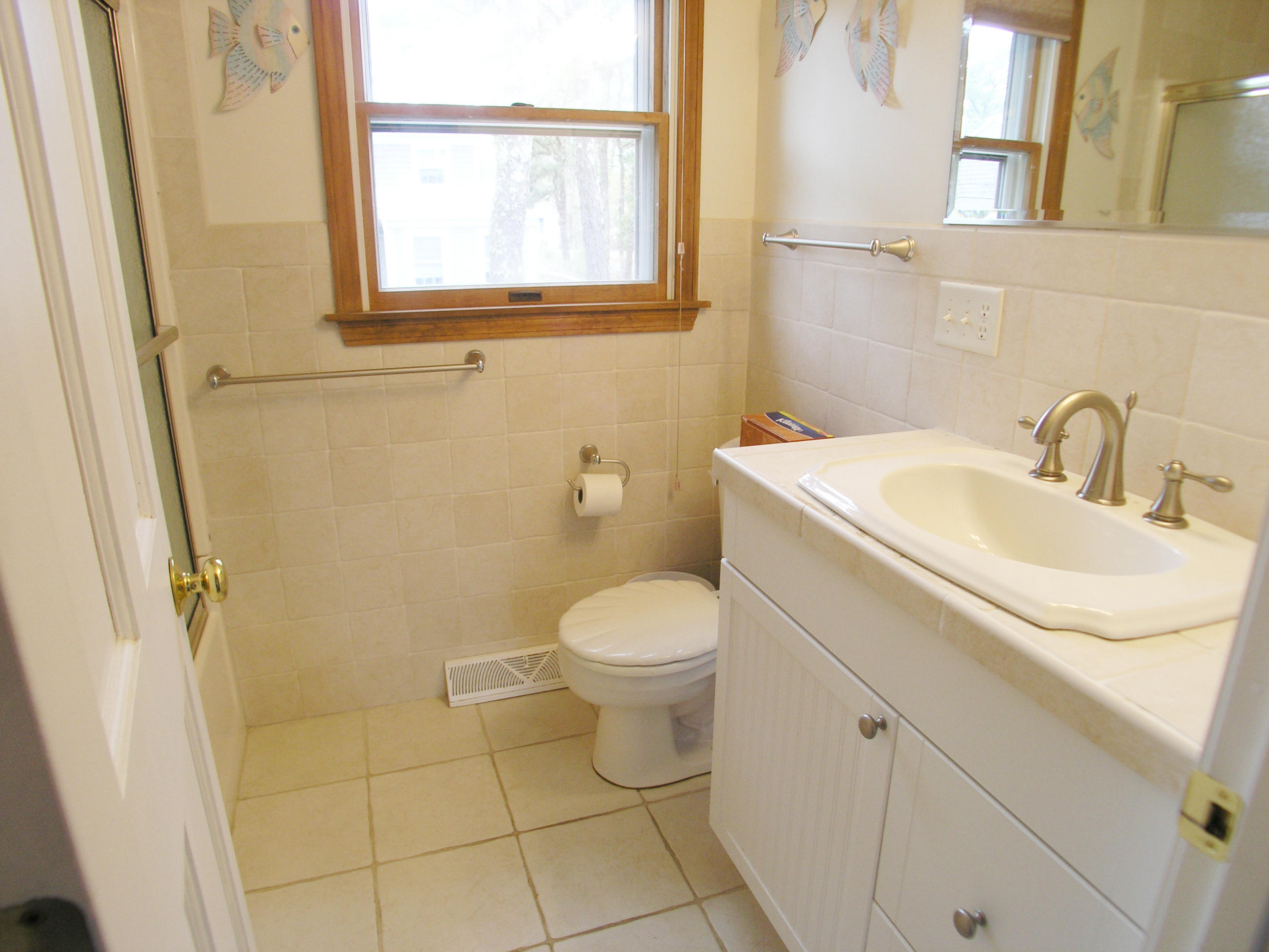 61 Bain Road Dennis Port, MA 02639 - Photo 11 of 22 a bathroom with a sink a toilet and a mirror