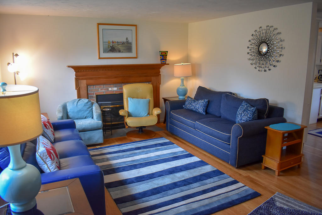 61 Bain Road Dennis Port, MA 02639 - Photo 2 of 22 a living room with furniture a fireplace and a lamp