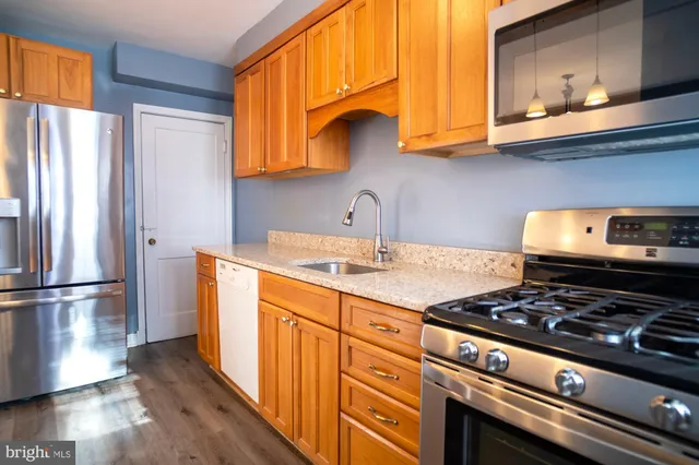 a kitchen with stainless steel appliances granite countertop a sink stove and refrigerator