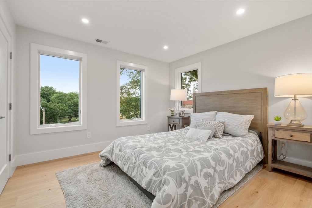 2202 Commonwealth Avenue, Unit 1 Newton, MA 02466 - Photo 23 of 34 a bedroom with a large bed and a night stand