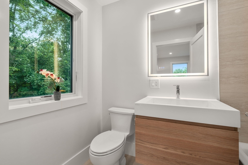 2202 Commonwealth Avenue, Unit 1 Newton, MA 02466 - Photo 24 of 34 a bathroom with a toilet a sink and a mirror