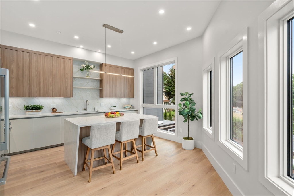 2202 Commonwealth Avenue, Unit 1 Newton, MA 02466 - Photo 10 of 34 a kitchen with a sink and chairs