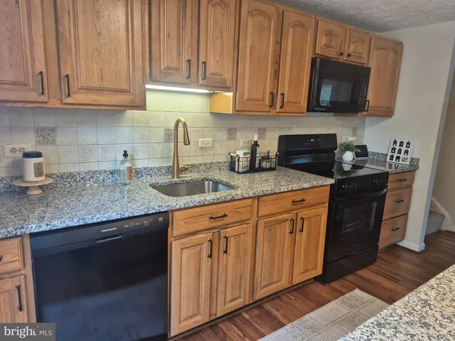 a kitchen with stainless steel appliances granite countertop a sink stove and microwave
