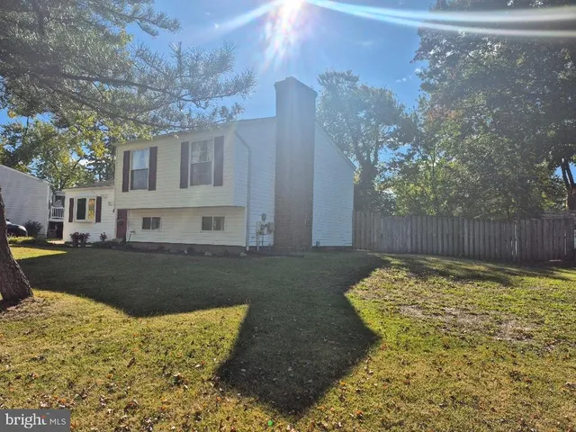 a view of a house with a large tree and a yard