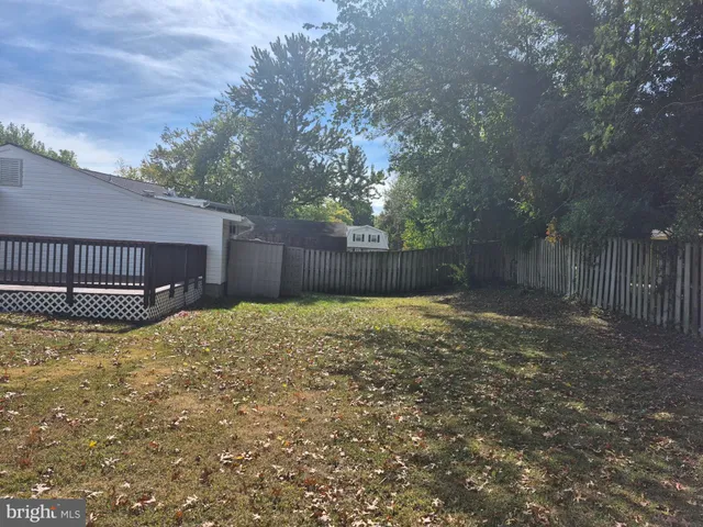 a view of a backyard with wooden fence