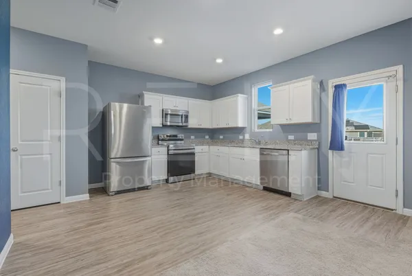a kitchen with stainless steel appliances granite countertop a refrigerator sink and stove