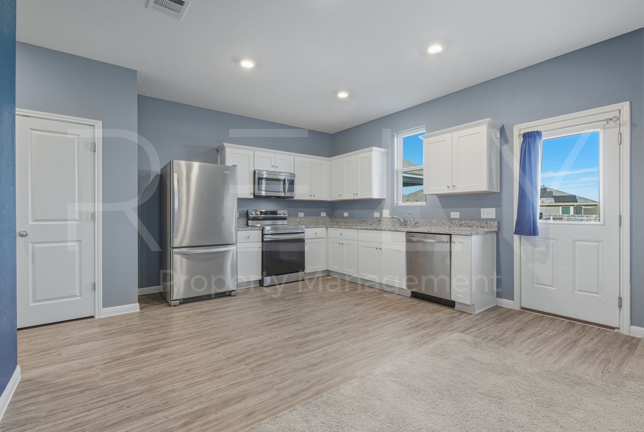 220 Wonderful Life Way Jarrell, TX 76537 - Photo 13 of 35 Kitchen with stainless steel appliances, white cabinets, light wood-type flooring, recessed lighting, and light stone counters