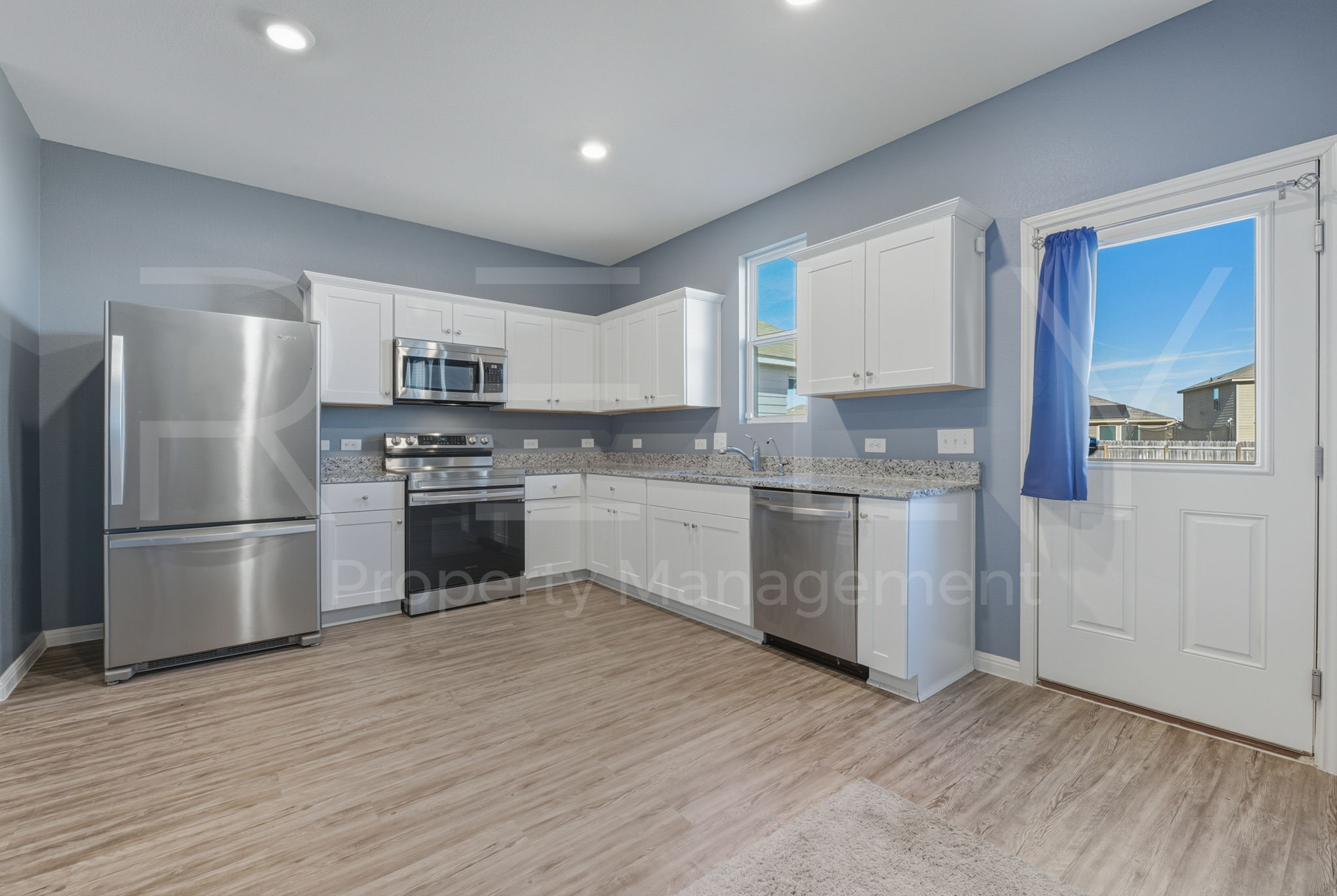 220 Wonderful Life Way Jarrell, TX 76537 - Photo 15 of 35 Kitchen with stainless steel appliances, white cabinets, light wood finished floors, light stone countertops, and recessed lighting