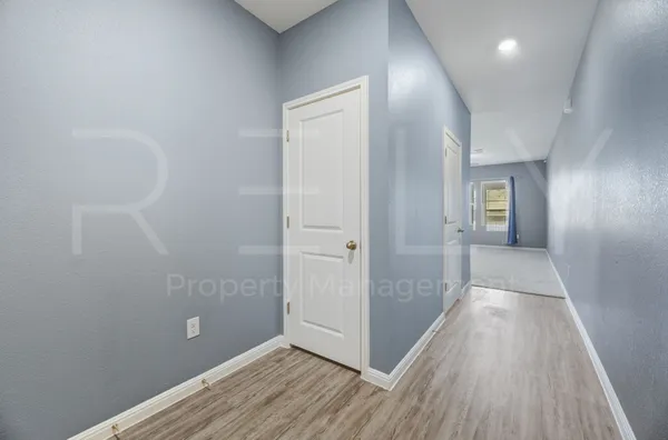 a view of a hallway with wooden floor