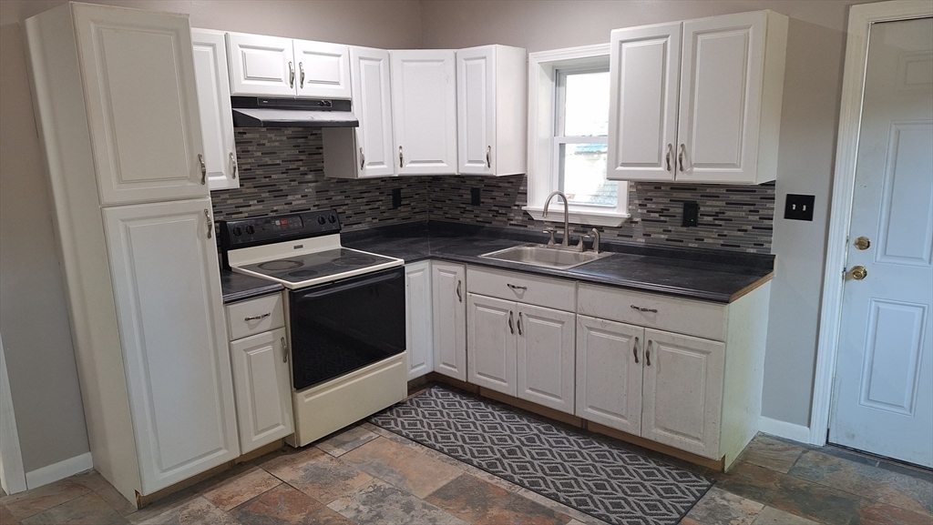 51 View Street Holyoke, MA 01040 - Photo 7 of 16 a kitchen with granite countertop white cabinets and white appliances