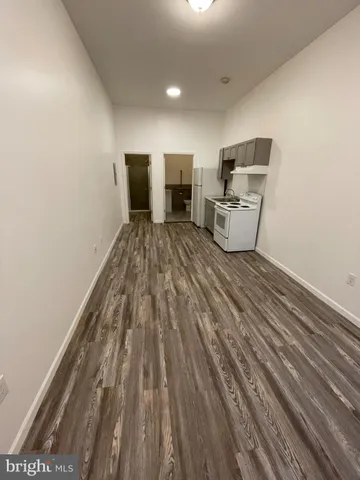 a view of a hallway with wooden floor and glass door