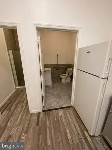 a view of a hallway with wooden floor and closet