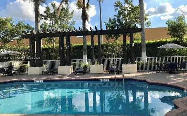 a view of swimming pool with lake view and a patio