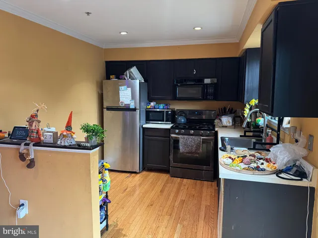 a kitchen with a refrigerator and a stove top oven