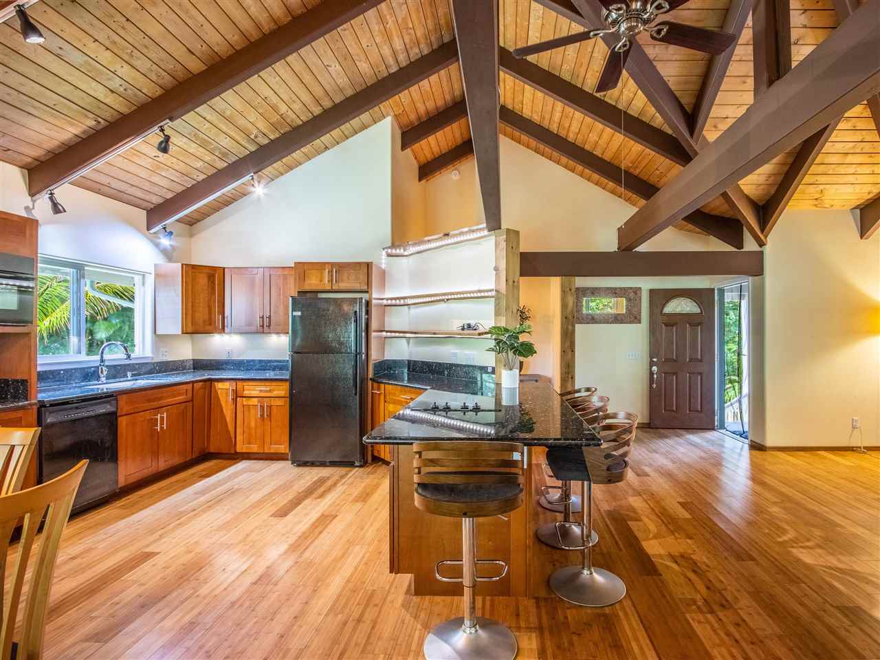 4508 Waha Place Haiku, HI 96708 - Photo 9 of 30 a kitchen with stainless steel appliances kitchen island granite countertop a table chairs and a wooden floors