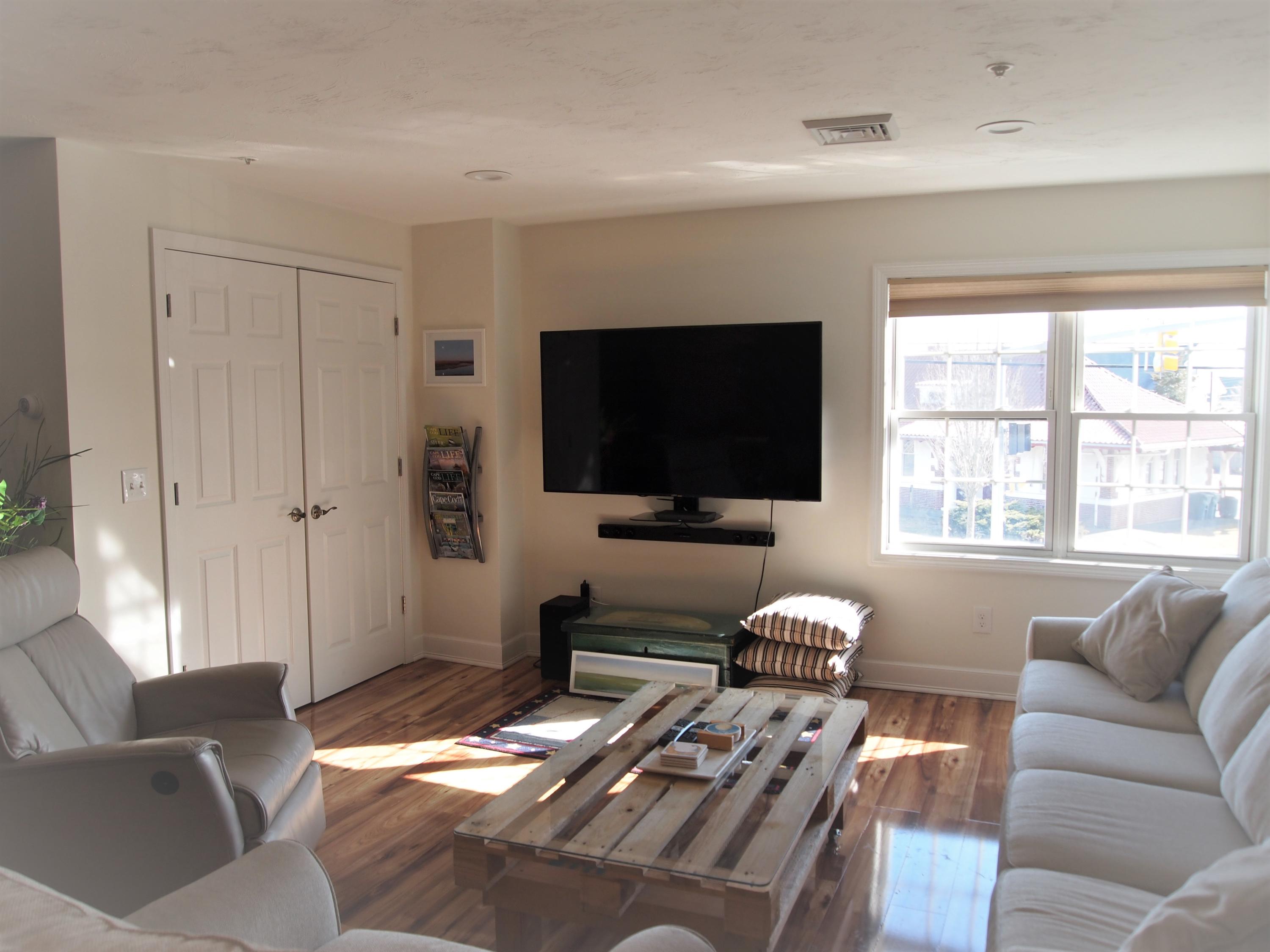 49 E Main Street Buzzards Bay, MA 02532 - Photo 4 of 15 a living room with furniture a flat screen tv and a window