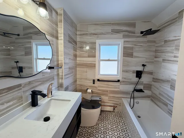 a bathroom with a sink a toilet and shower
