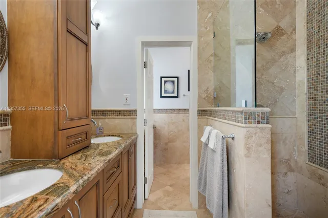 a bathroom with a granite countertop sink and a washing machine