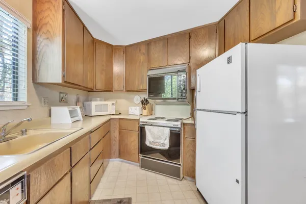 a kitchen with a refrigerator sink and cabinets