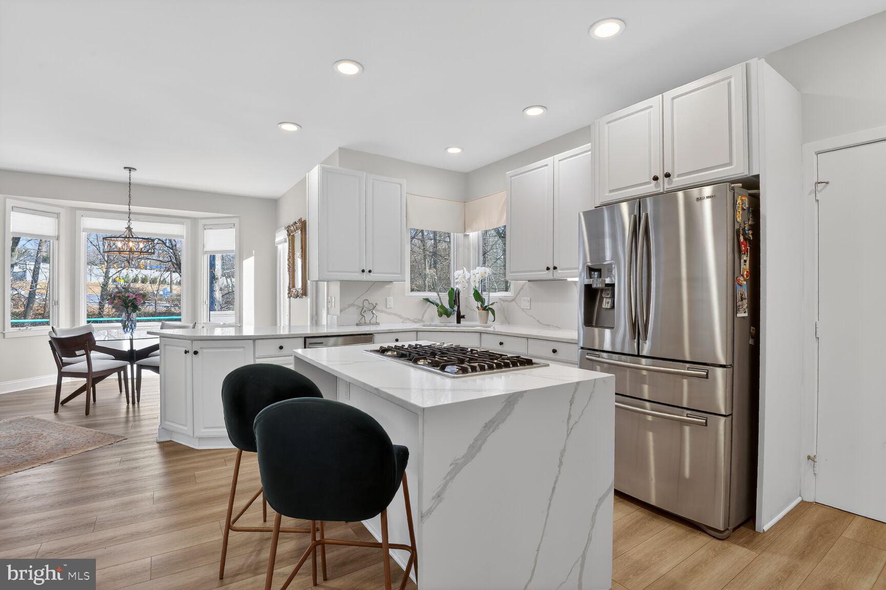 11300 Water Pointe Circle Reston, VA 20194 - Photo 13 of 36 a kitchen with stainless steel appliances granite countertop a stove a refrigerator a sink a dining table and chairs with wooden floor