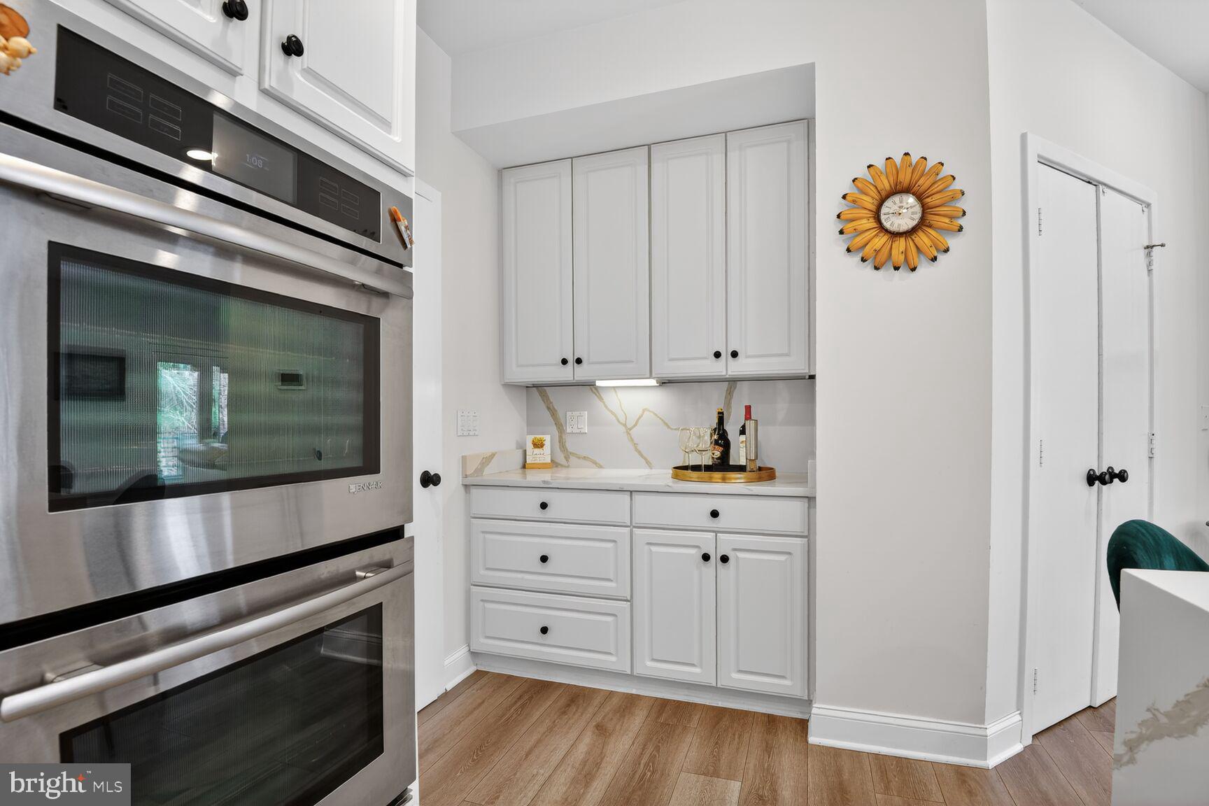 11300 Water Pointe Circle Reston, VA 20194 - Photo 15 of 36 a kitchen with stainless steel appliances white cabinets and a wooden floor