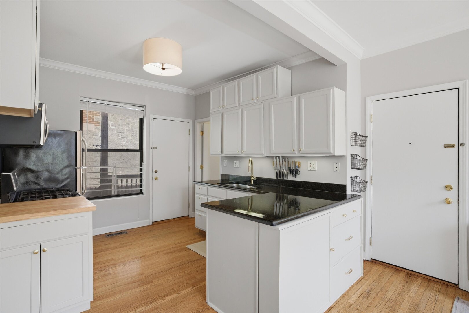 1958 West George Street, Unit 1 Chicago, IL 60657 - Photo 4 of 30 a kitchen with granite countertop a sink a stove and cabinets with wooden floor