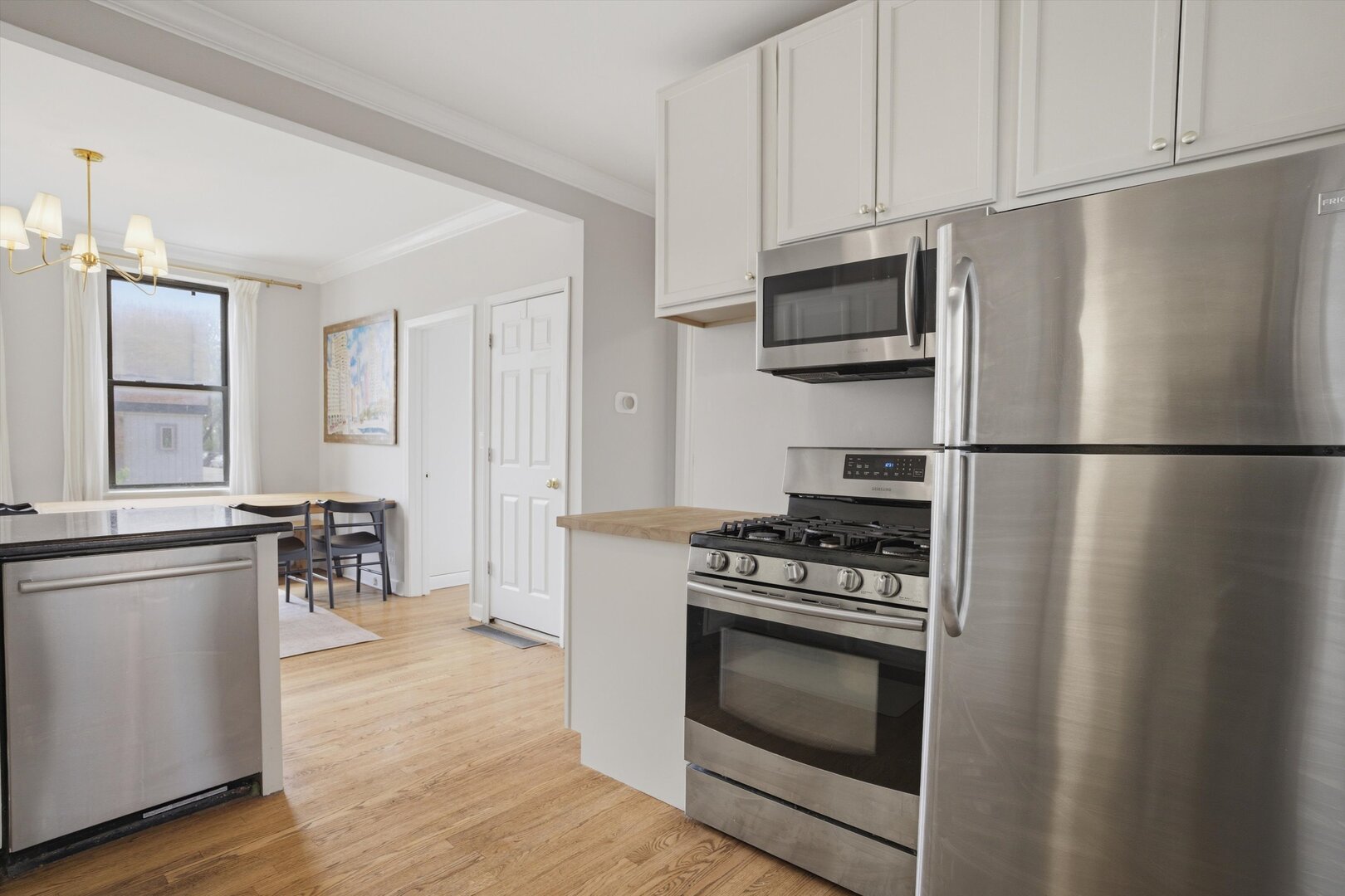 1958 West George Street, Unit 1 Chicago, IL 60657 - Photo 7 of 30 a kitchen with stainless steel appliances a stove a microwave and a refrigerator