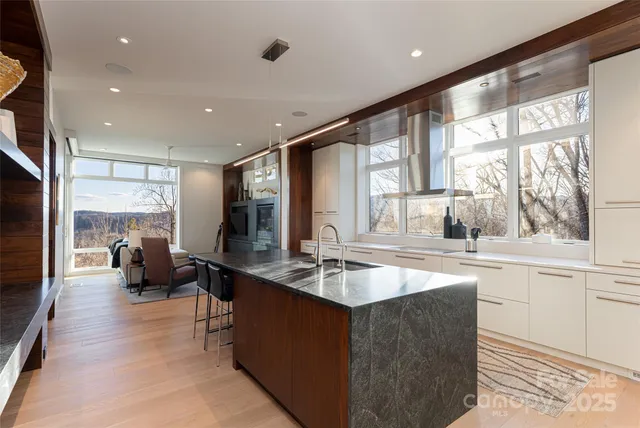 a large kitchen with kitchen island a large window in it