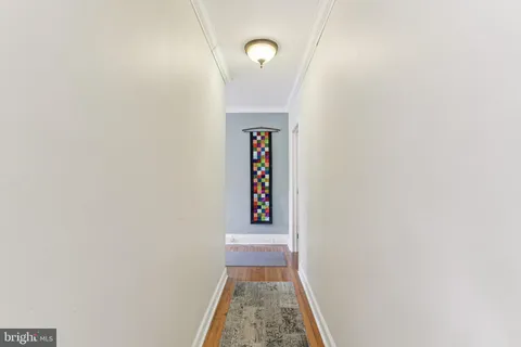 a view of a hallway with wooden floor and entryway