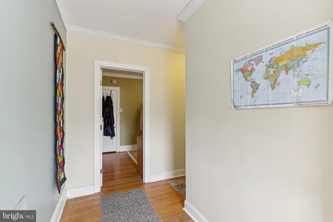 a view of a hallway with wooden floor and a bookshelf