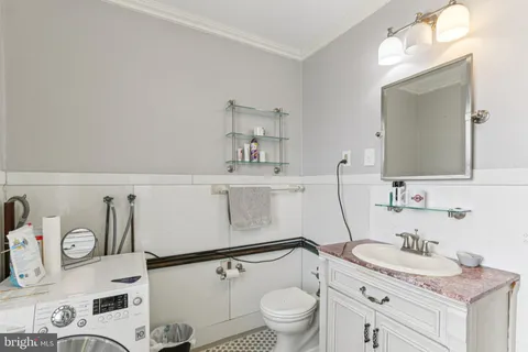 a bathroom with a granite countertop sink mirror vanity and toilet