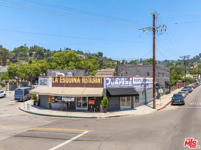 a view of a building with a garden and car parked