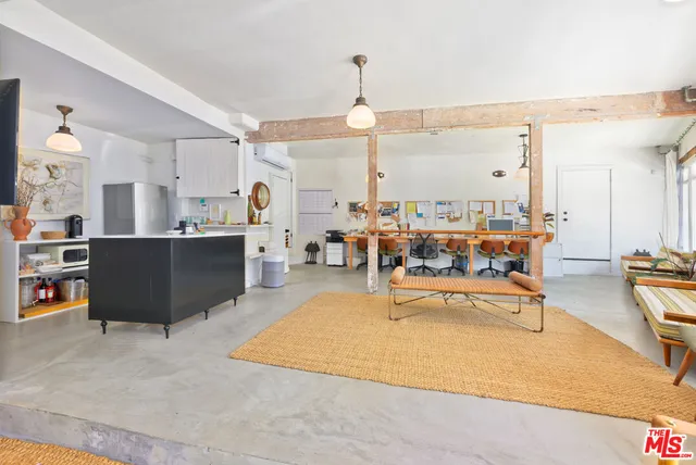 a living room with couches chairs and large view with kitchen countertops