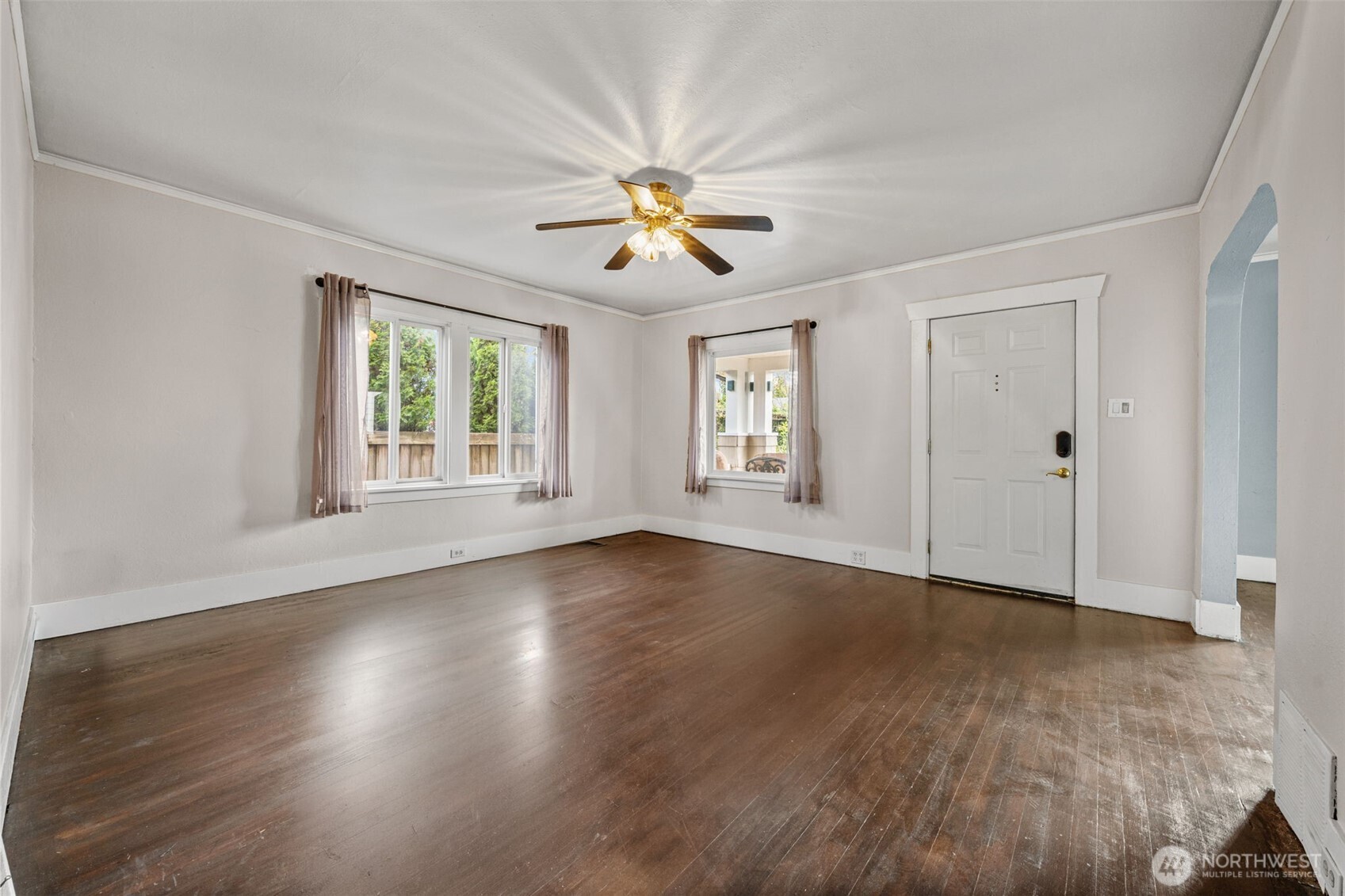 616 South Adams Street Tacoma, WA 98405 - Photo 4 of 26 an empty room with wooden floor chandelier fan and windows