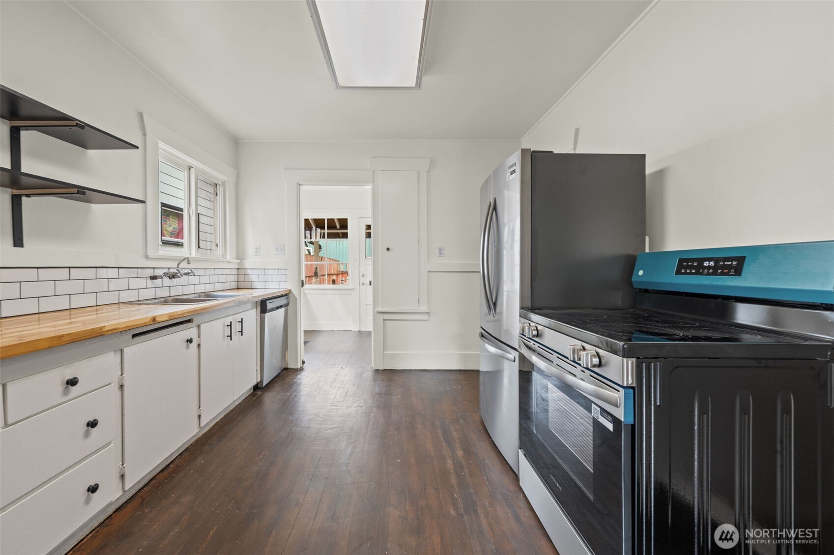 616 South Adams Street Tacoma, WA 98405 - Photo 9 of 26 a kitchen with stainless steel appliances a stove refrigerator sink and wooden floor