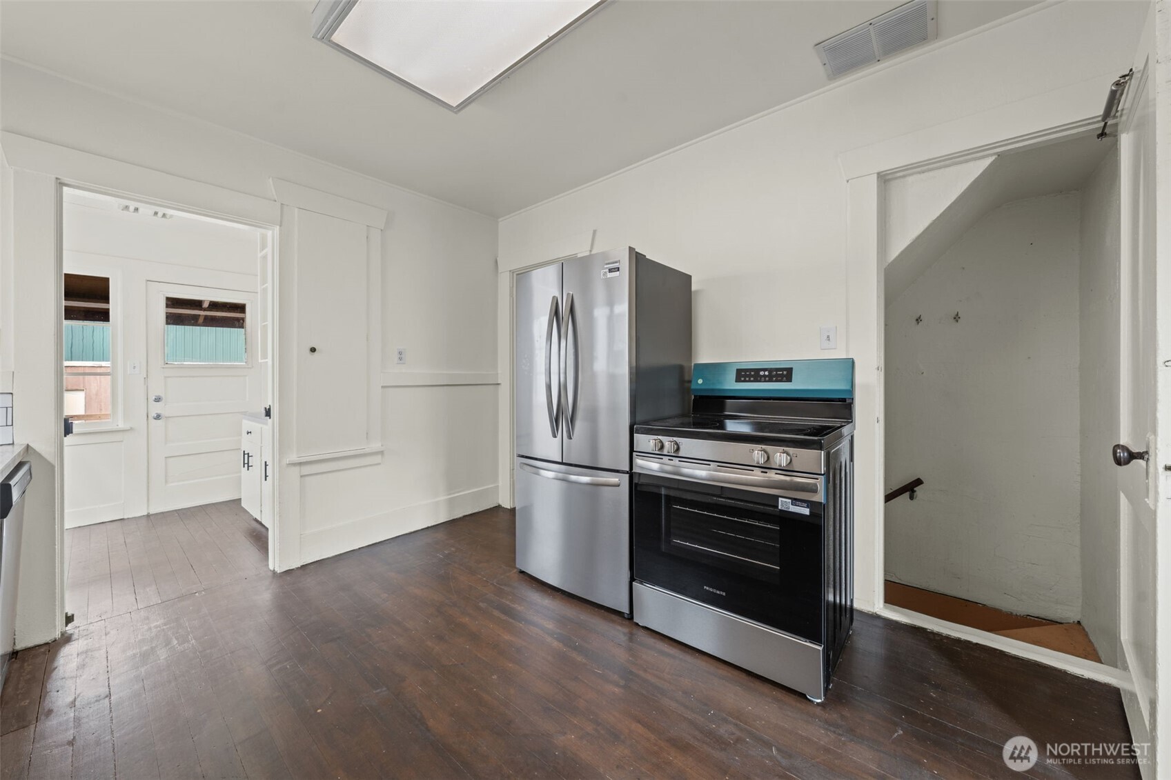 616 South Adams Street Tacoma, WA 98405 - Photo 10 of 26 a kitchen with stainless steel appliances and wooden floor