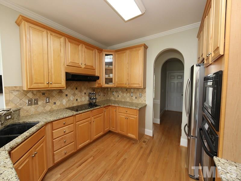 1024 Pasture View Lane Raleigh, NC 27603 - Photo 10 of 20 a kitchen with granite countertop wooden cabinets a sink a window and stainless steel appliances